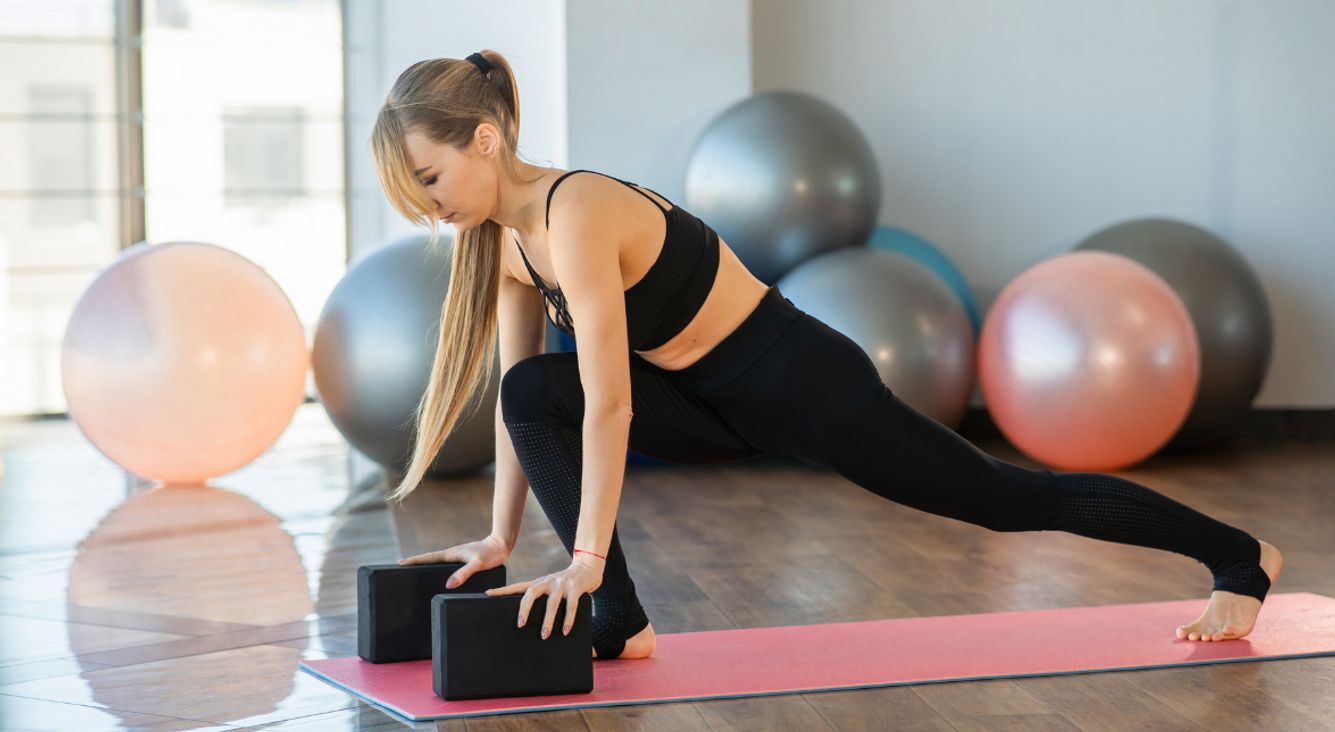  Person bei tiefem Lunge mit Yoga-Block