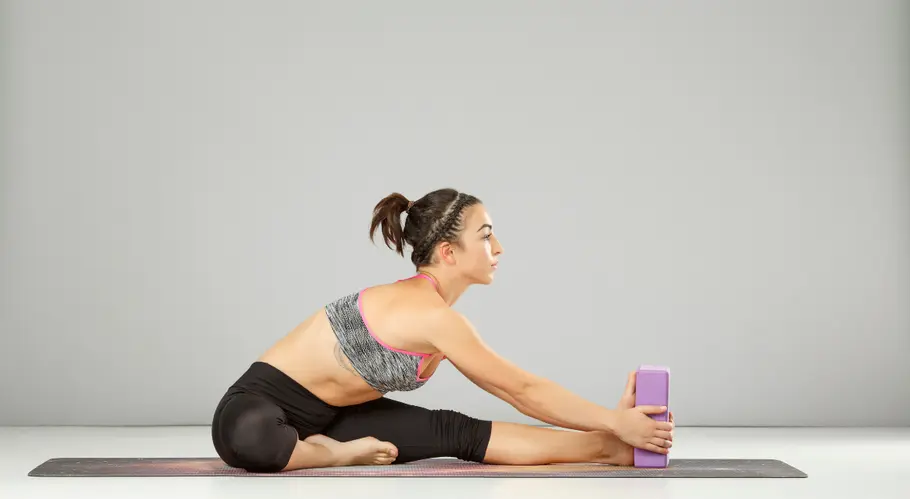 5 kraftvolle Yoga-Block-Übungen Person bei sitzender Vorbeuge mit Yoga-Block