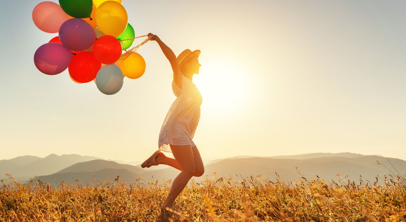 Frau auf Feld mit Luftballons