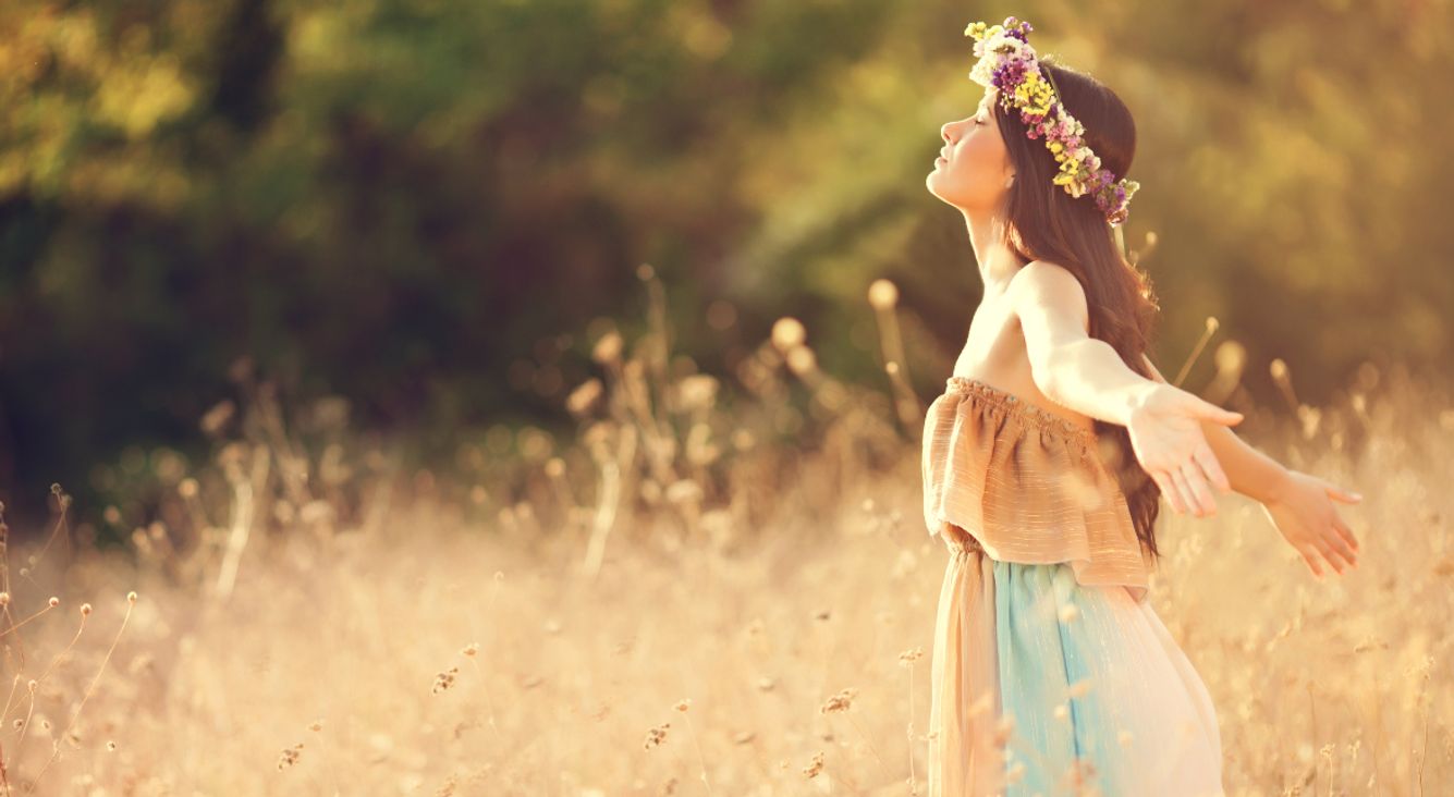 Person mit Blumenkranz in Feld