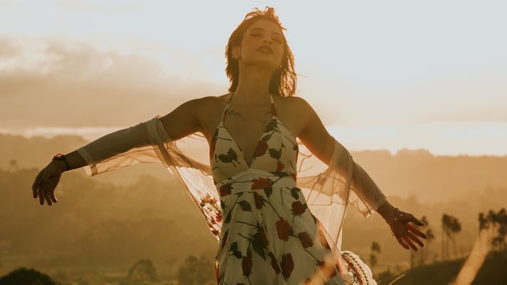 Frau in Blumenkleid auf Wiese - Foto: canva.com