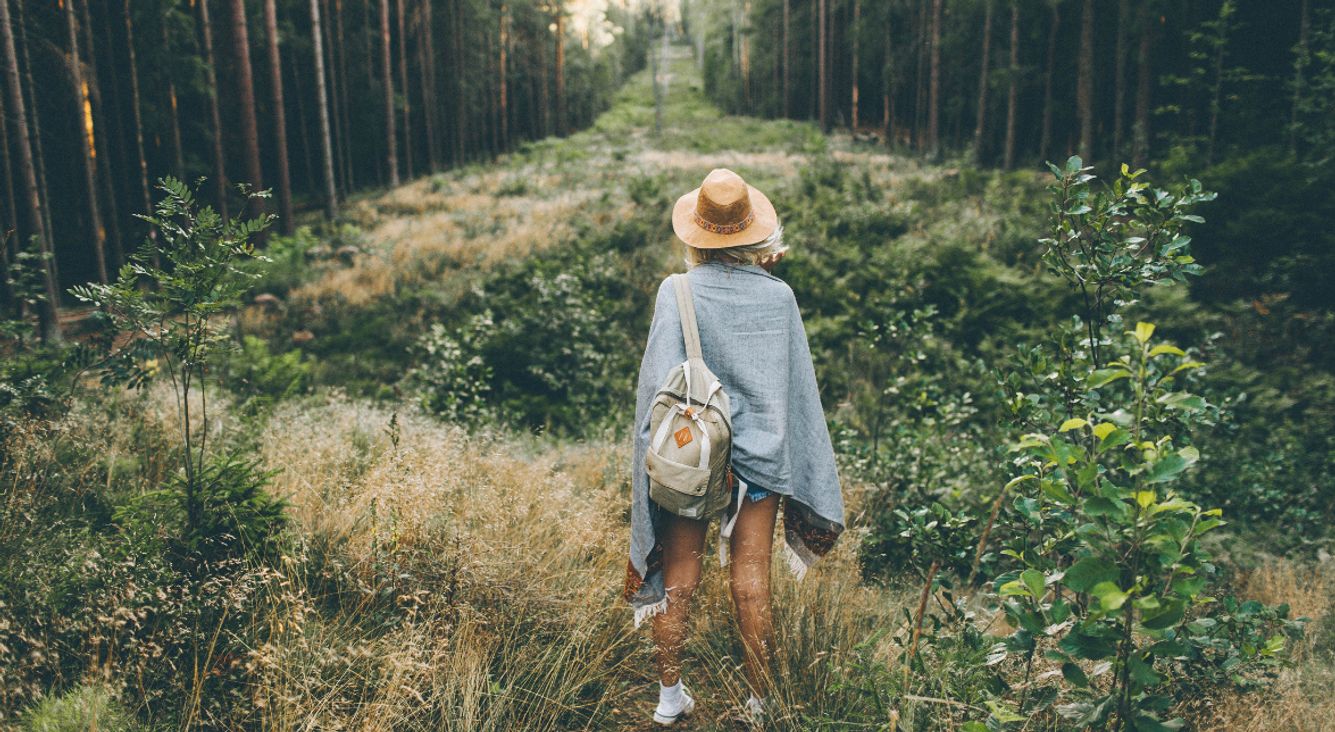 Frau steht im Wald