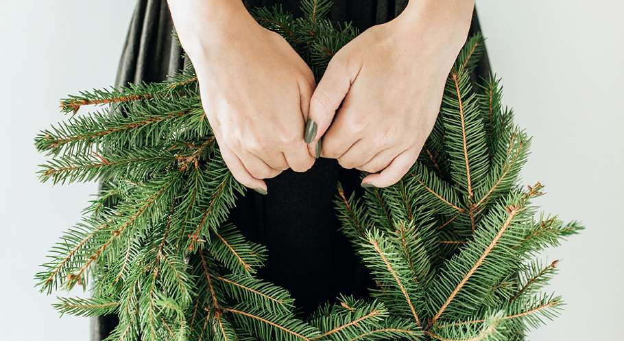 Frau hält Adventskranz