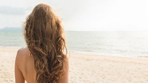 Frau am Strand mit schönen Haaren - Foto: canva.com