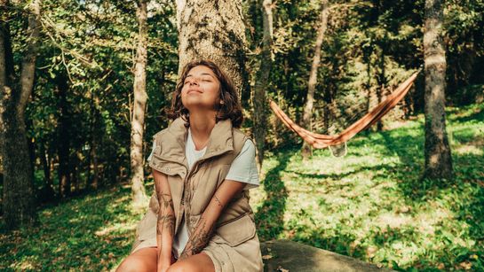 Frau genießt die Sonnenstrahlen in der Natur - Foto: canva.com