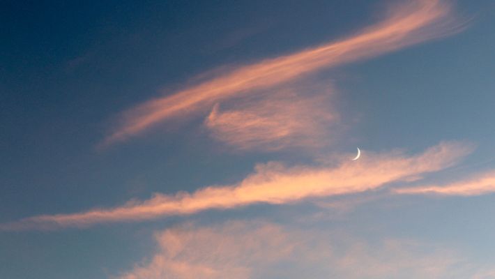 Neumond am blauen Himmel mit rosa Wolken - Foto: canva.com