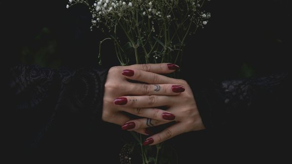 Frau mit rotem Nagellack hält einen Strauss Schleierkraut in der Hand - Foto: canva.com