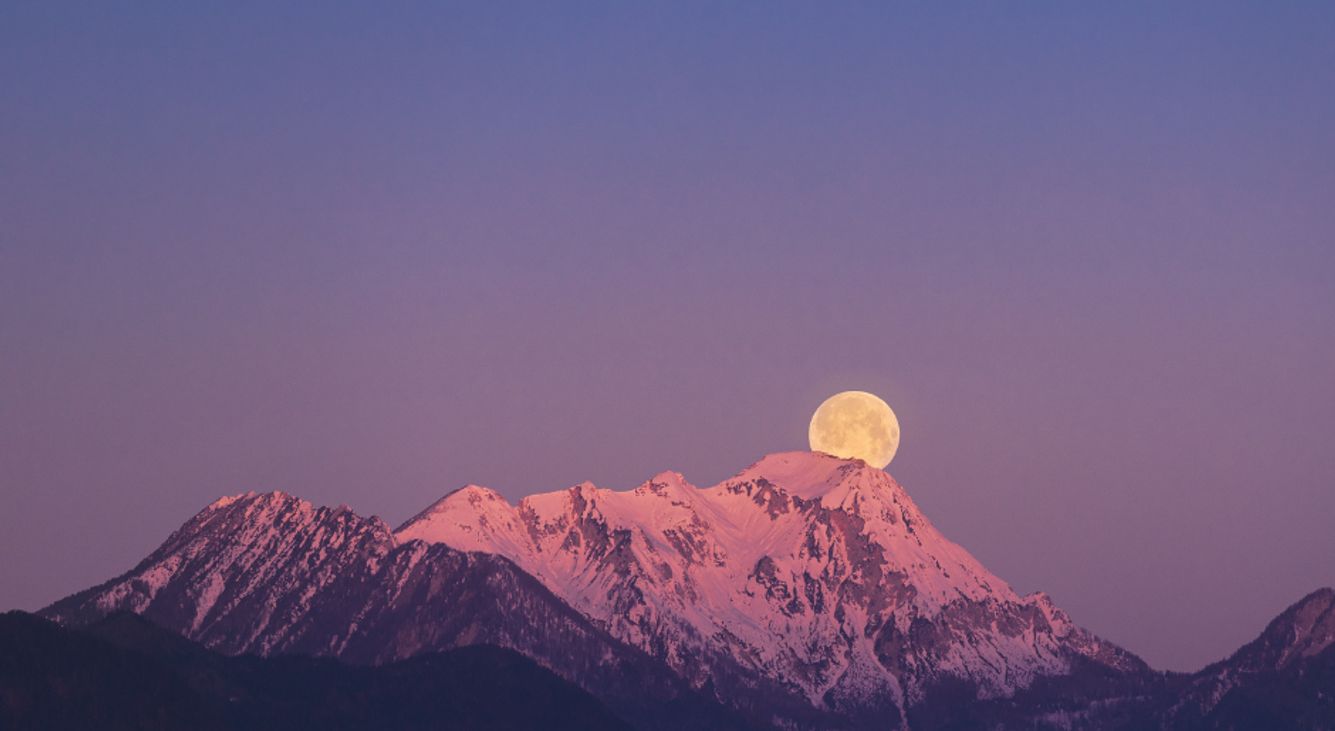 Vollmond über einem Berg mit Schnee