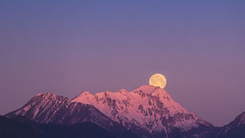 Vollmond über einem Berg mit Schnee - Foto: canva.com