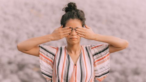 Frau in der Natur hält sich die Finger über die Augen - Foto: canva.com