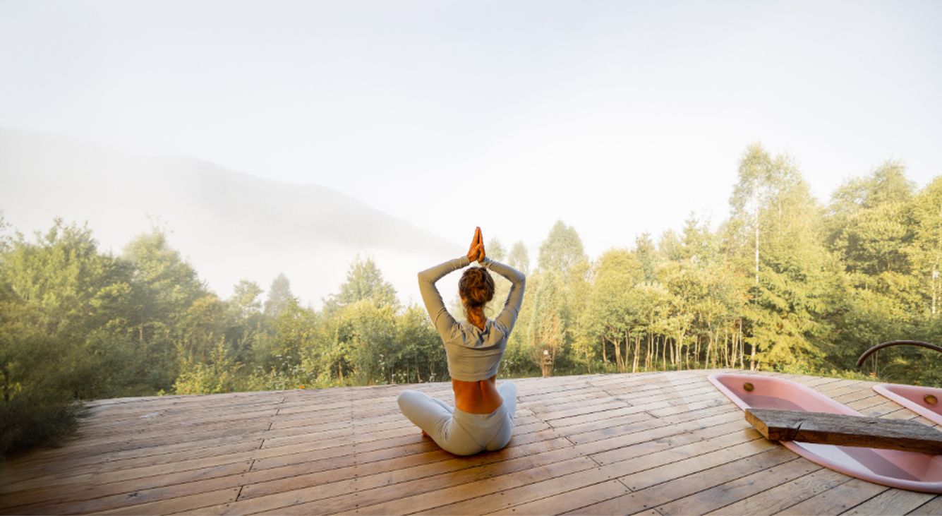 Frau macht Yoga auf Steg bei Sonnenaufgang