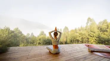 Frau macht Yoga auf Steg bei Sonnenaufgang - Foto: canva