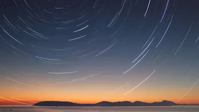 Blick in den dunklen Himmel mit Lichtreflexen darauf - Foto: canva.com