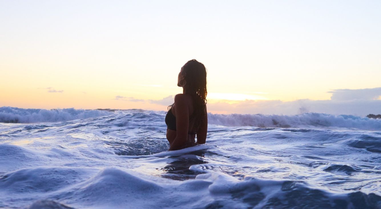 Frau steht im Meer