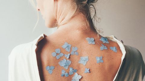 Craniosacrale Therapie Frau Rücken Blumen - Foto: canva.com