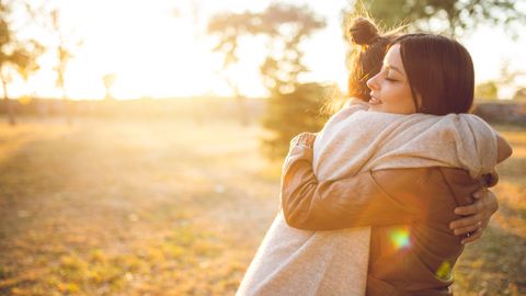 Frauen umarmen sich auf Wiese - Foto: canva.com