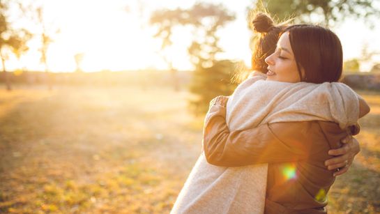 Frauen umarmen sich auf Wiese - Foto: canva.com