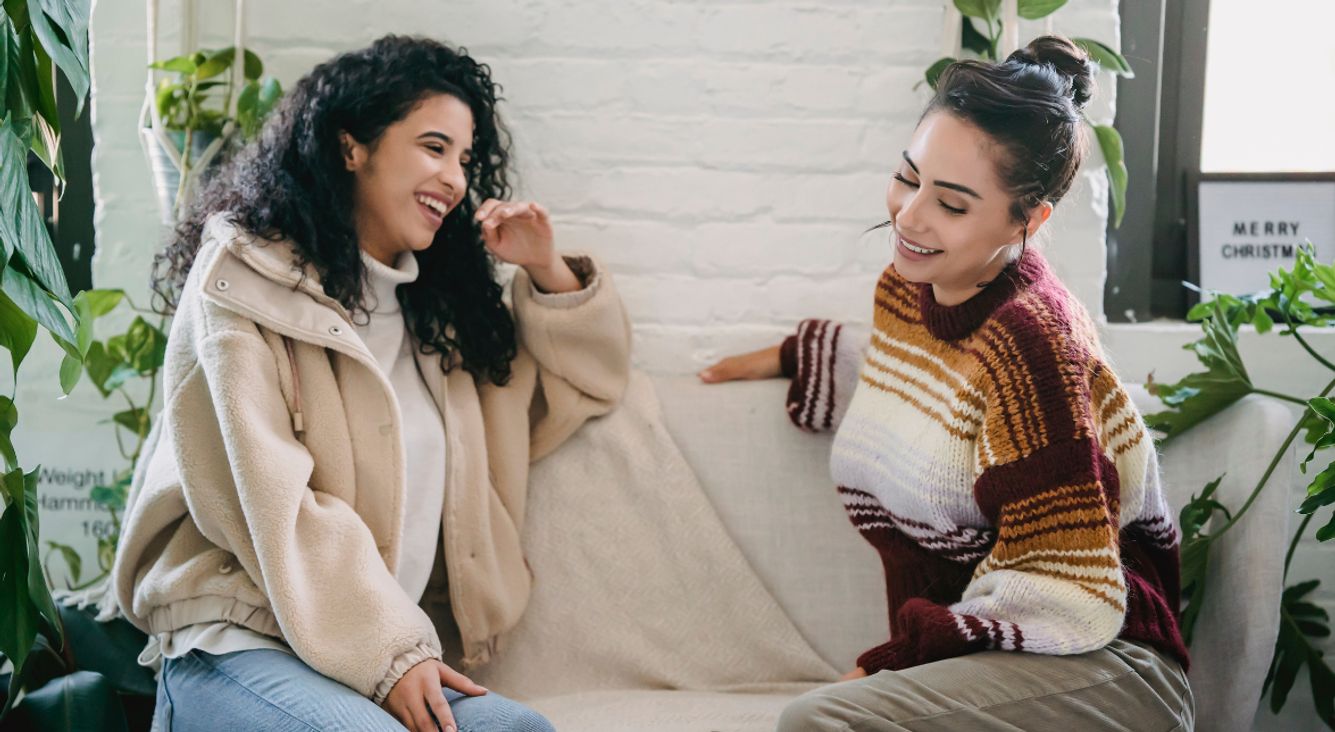 Zwei Frauen unterhalten sich auf Sofa