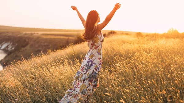 Person in Kleid in Feld bei Sonnenuntergang - Foto: canva,com