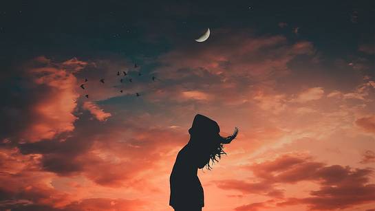 Frau steht vor rotem Himmel und Mondsichel - Foto: Pexels