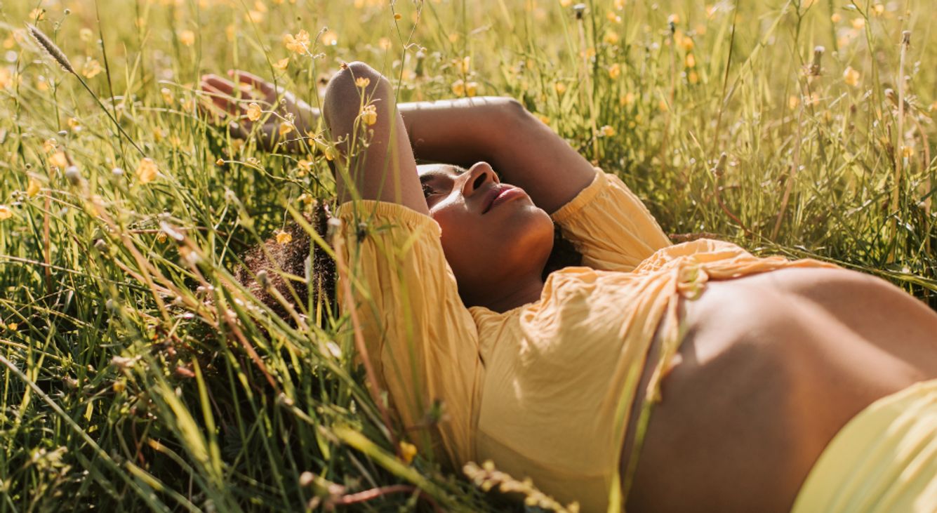 Grüne Kraft: So lebst du im Einklang mit der Natur Person liegt in Blumenwiese