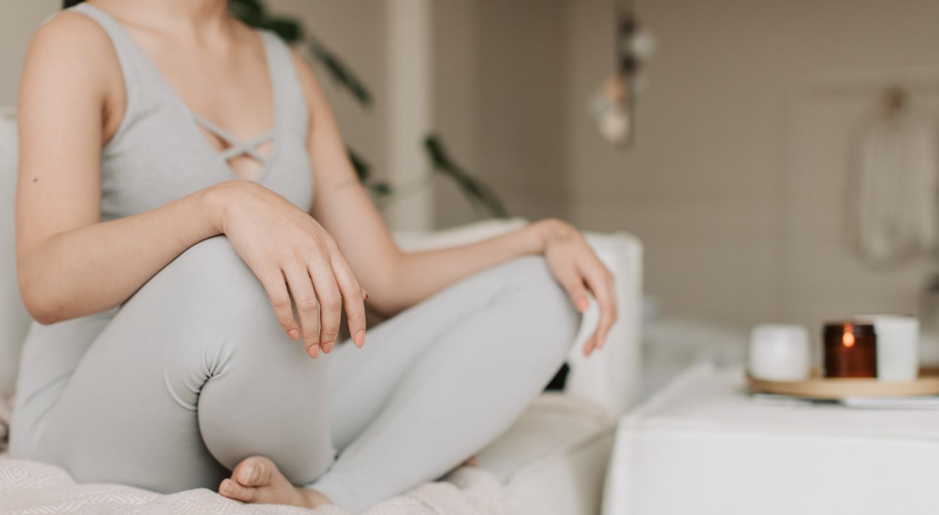 Person auf Sofa in Schneidersitz