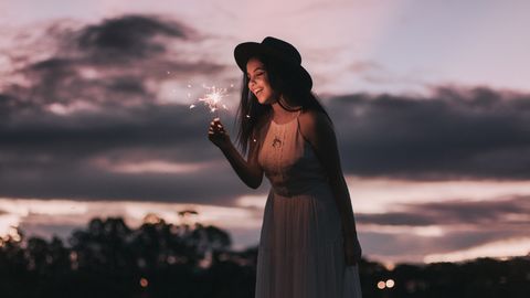 Person mit Wunderkerze vor dunklem Himmel - Foto: canca.com