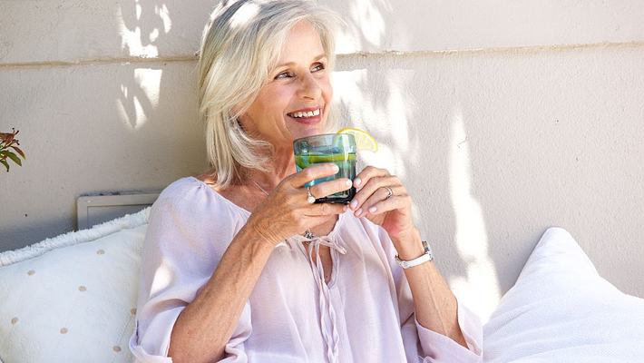 Ältere Frau mit Glas in Bett - Foto: canva.com