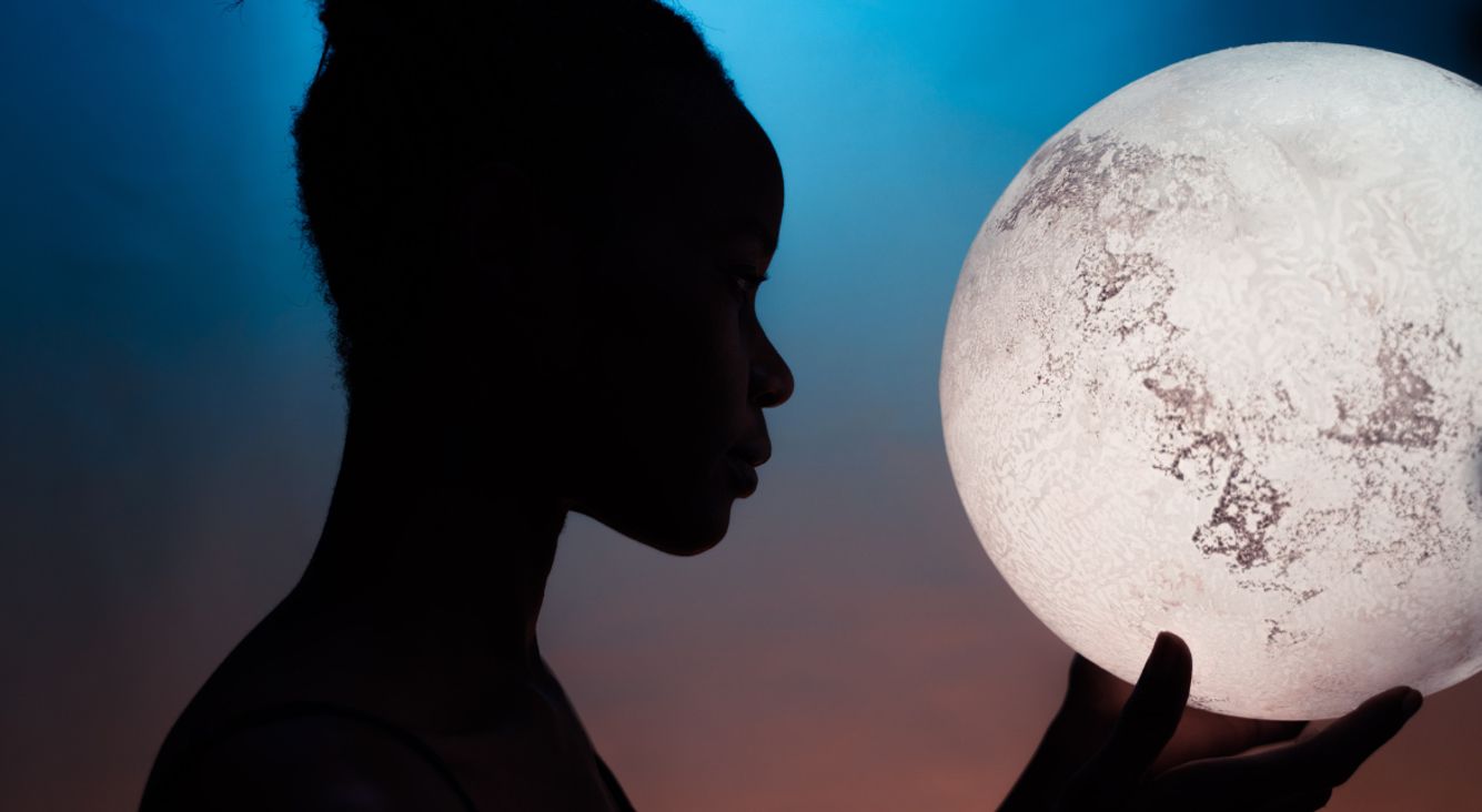 Silhouette einer Frau mit Mond in den Händen