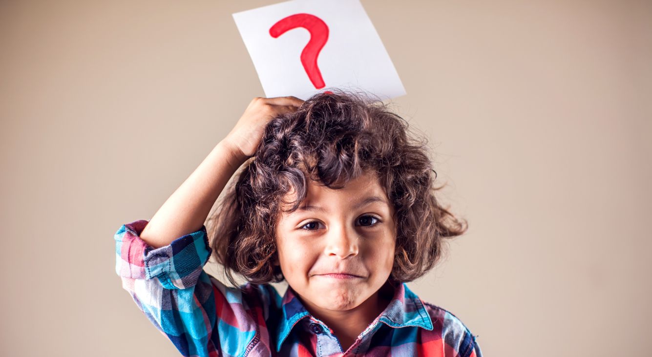 Kind mit Fragezeichen-Schild auf Kopf