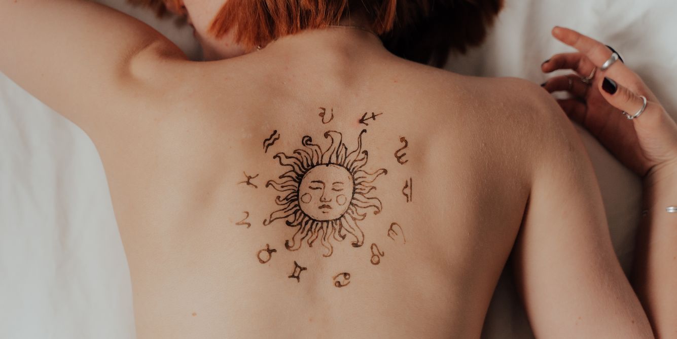 Frau mit Sternzeichen-Tattoo auf dem Rück
