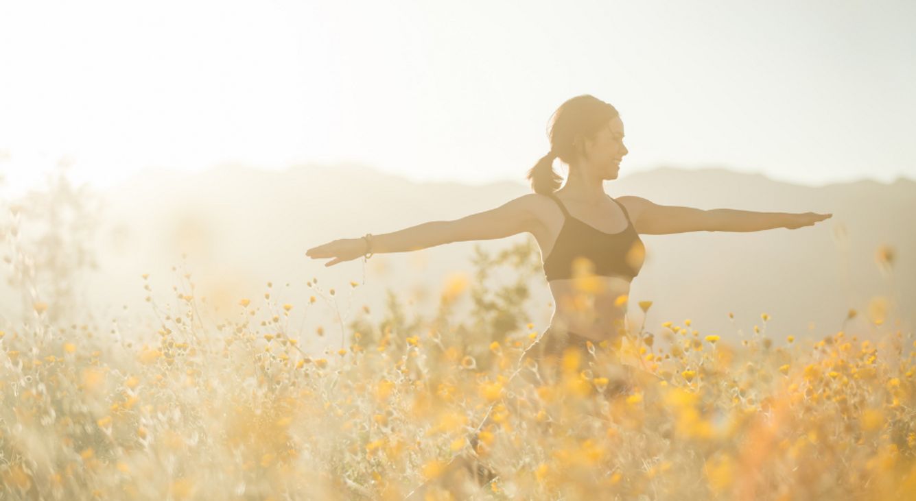 Frau macht Yoga auf Blumenwiese