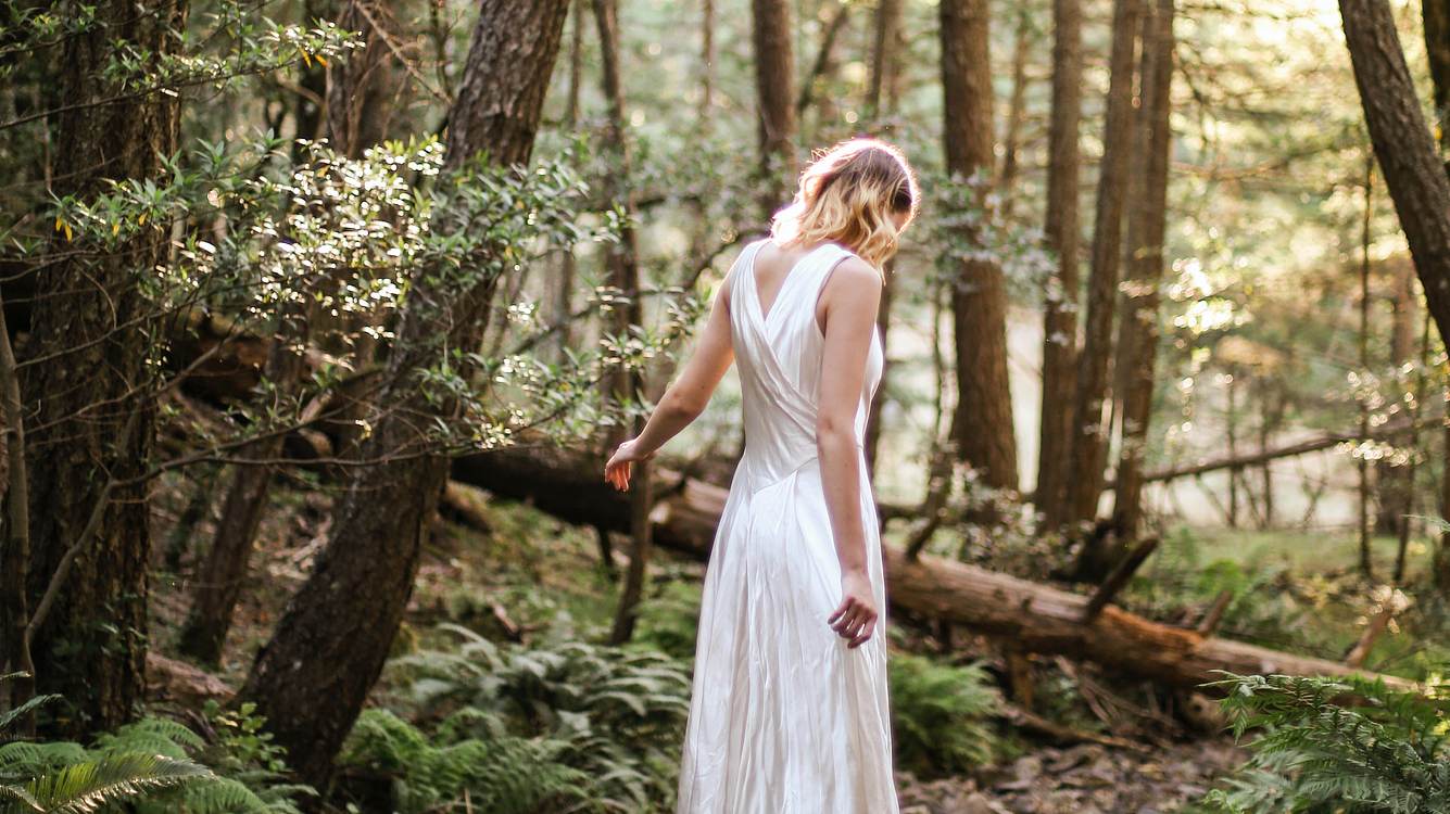 Frau im Wald in weißem Kleid 