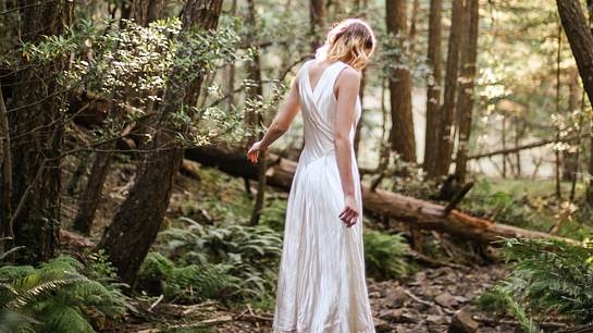 Frau im Wald in weißem Kleid  - Foto: Kitera Dent / Unsplash