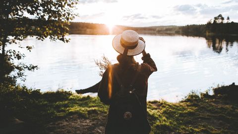 Person steht in Natur an See - Foto: canva.com