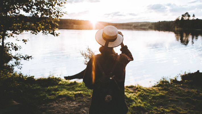 Person steht in Natur an See - Foto: canva.com