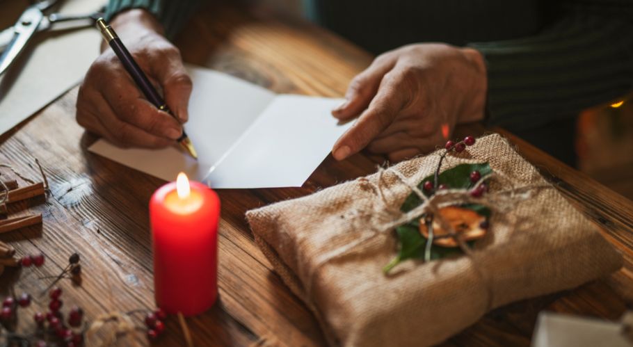 Person schreibt Weihnachtskarte