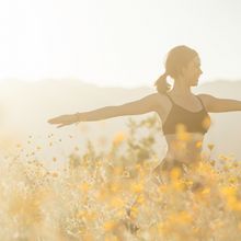 Frau macht Yoga im Blumenfeld Krieger